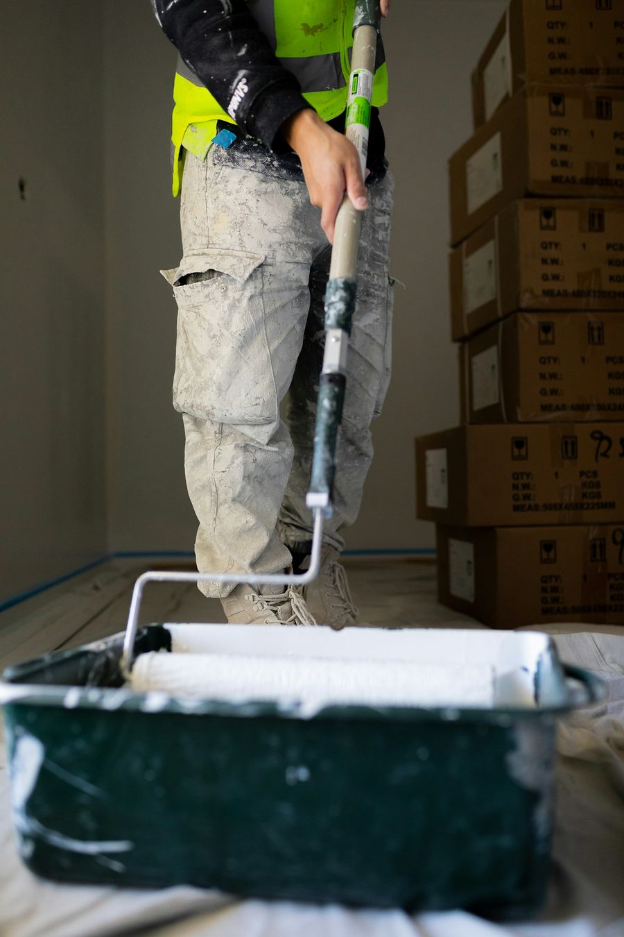 Painter loading a roller with fresh white paint